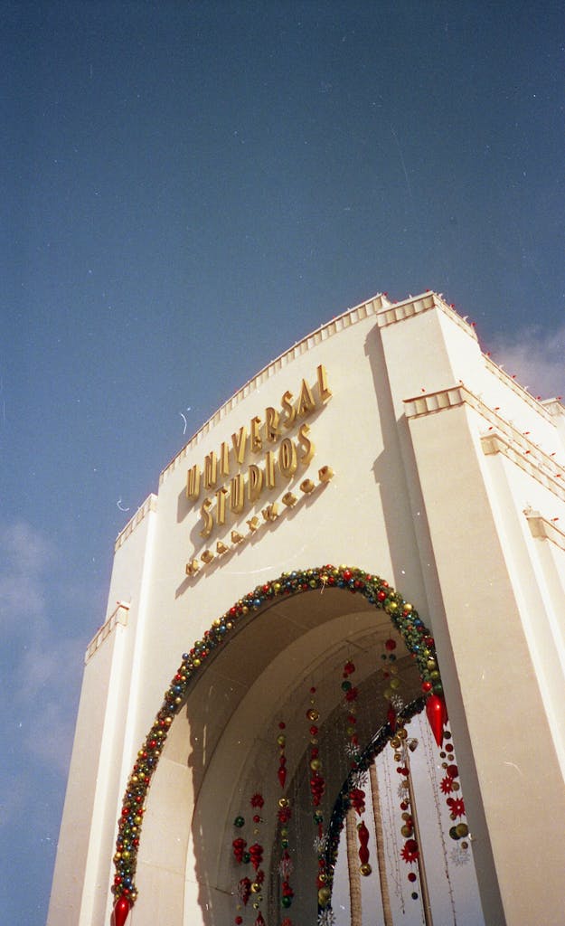 A festive view of the Universal Studios entrance adorned with holiday decorations.